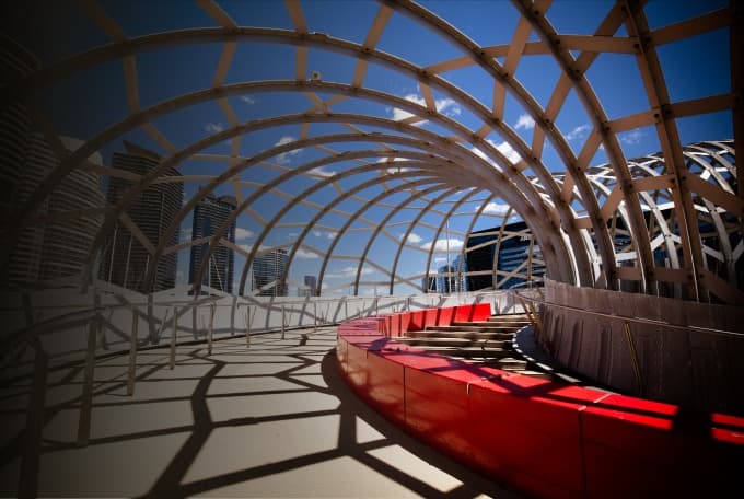 Timber lattice pavilion over a red walkway