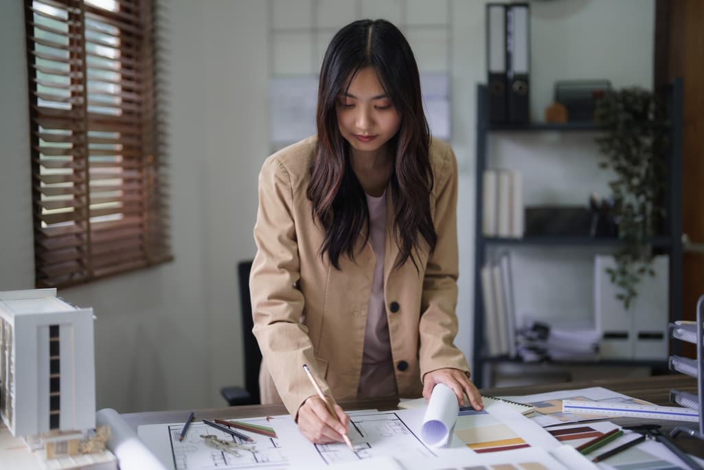 Interior designer sketching at a desk with material samples