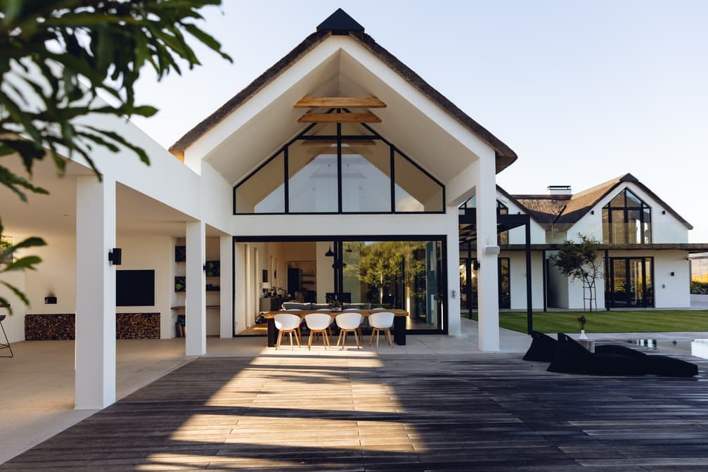 Rendered modern gabled house with a glass facade and a timber deck