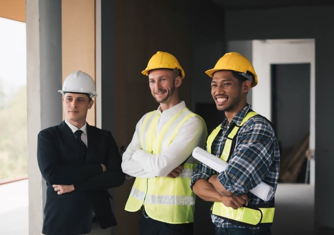Builders in hard hats and high-vis vests with a developer on site