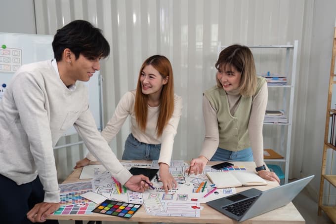 Design students working with colour swatches and sketches at a table