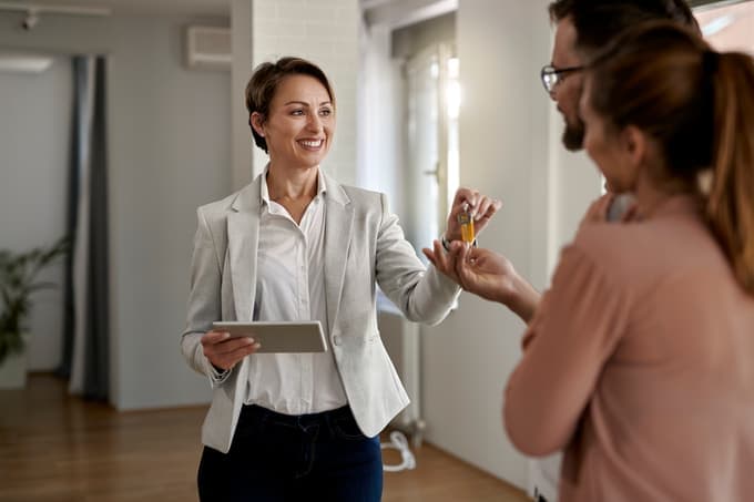 Real estate agent handing house keys to a couple